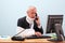 Injured businessman at his desk on the phone