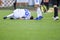 The injured footballer lies on the pitch