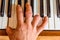 Injured male hand on the shiny piano keys. Top view