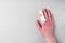 Injured painful finger with white gauze bandage on gray background