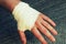 Injured painful hand with white gauze bandage