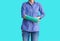 Injured woman with green cast on hand and arm on blue background