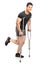 Injured young male athlete walking with crutches