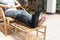 injury woman with black splint on leg sitting on wooden chair a