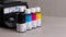 Inkjet four-color printer with continuous ink supply and ink bottles for refilling on gray background