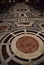 Inlaid floor of the cathedral of Santa Maria in Fiore in Florence, with a large circle in the foreground and others further away.