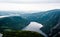 Inland fjord between steep cliffs against green landscape