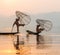 Inle, Myanmar - March 2019: two traditional Burmese leg rowing fishermen at Inle lake