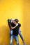 Inlove young couple posing in fashion style on yellow wall