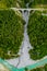 Inn River flowing in the forest in Switzerland. Aerial view from drone on an old railway bridge viaduct in the mountains