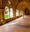 Inner cloister of an abbey with a monk walking and praying