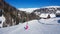 Innerkrems - A snowboarding woman in pink outfit going down the slope in Innerkrems, Austria. There is s snow-capped cottage