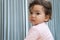 Innocence toddler girl sitting relaxed on the bed while looking at parent at home. Adorable little infant baby thinking something