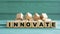 INNOVATE - word on wooden cubes on a green background