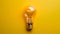 Innovative concept vibrant yellow background highlights illuminated light bulb