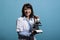 Insane looking scientist smiling creepy while having modern microscope instrument on blue background.