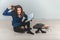 Insane young teacher with tousled hair, setting her teeth, tearing out her hair, sitting on the floor.