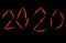 Inscription 2020 on a black background , composed of pods of red hot pepper
