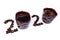 Inscription of 2020 number made of two cups of coffee and coffee beans laid out on white background