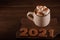 Inscription 2021 gingerbread cookie. Happy new year 2021 and marshmallows in a mug on a dark background close up and copy space. M