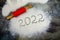 Inscription 2022 is made of flour on black concrete background. rolling pin, flour and numbers 2022