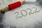 Inscription 2022 is made of flour on black concrete background. rolling pin, flour and numbers 2022