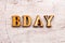 Inscription BD BDAY birthday abbreviation in wooden letters on a light background