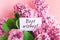 inscription best wishes on a white gift card in a beautiful bouquet of lilac