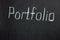 The inscription on the black board `Portfolio`. Collection of the best freelancer works