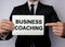 The inscription business coaching on white paper which to hold