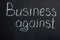 The inscription on the chalk board `Business against`