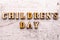Inscription CHILDRENS DAY in wooden letters on a light background