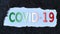 The inscription COVID-19 in the colors of the Italian flag in the window of torn paper. Concept of COVID-19. Coronavirus disease