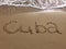 Inscription Cuba on the sandy beach and foamy sea water