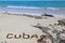 Inscription cube on the dense sand of the beach.