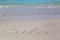 Inscription cube on the dense sand of the beach.