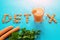 Inscription detox, top view, carrot juice in a glass on a blue background. Concept of a healthy diet, diet