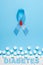 Inscription diabetes blue ribbon awareness with red blood drop and ruined wall made of sugar cubes on a blue background