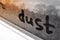 The inscription in the dust on dirty glass or car body, front and rear blurred background with bokeh effect