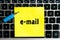 inscription `email` on a yellow sheet of sticker paper on the background of a computer keyboard