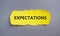 Inscription Expectations word on yellow torn papper