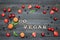 Inscription Go vegan and fruits. Black wooden background. Food c