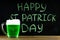 The inscription with green chalk on a chalkboard: Happy St. Patrick\'s Day. A mug with green beer.