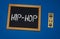 inscription HIP HOP on a black board with a blue background with three wooden cubes