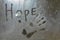 Inscription Hope and handprint on misted glass.