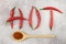 The inscription HOT is laid out from pods of red hot chili peppers on an abstract gray background