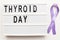 Inscription international thyroid day and violet ribbon on white background