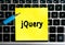 The inscription `jQuery` on a yellow sheet of sticker paper