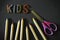 Inscription kids, colorful crayons and children`s scissors