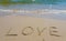 Inscription Love drawn on the sand. Concept of true and honest romantic feelings. spa novel on the sea